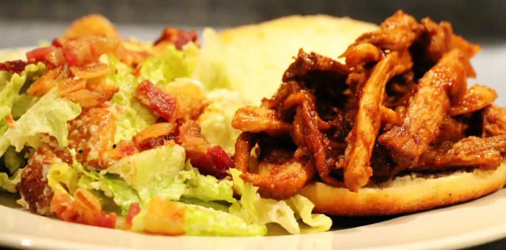 pulled pork sandwich and caesar salad