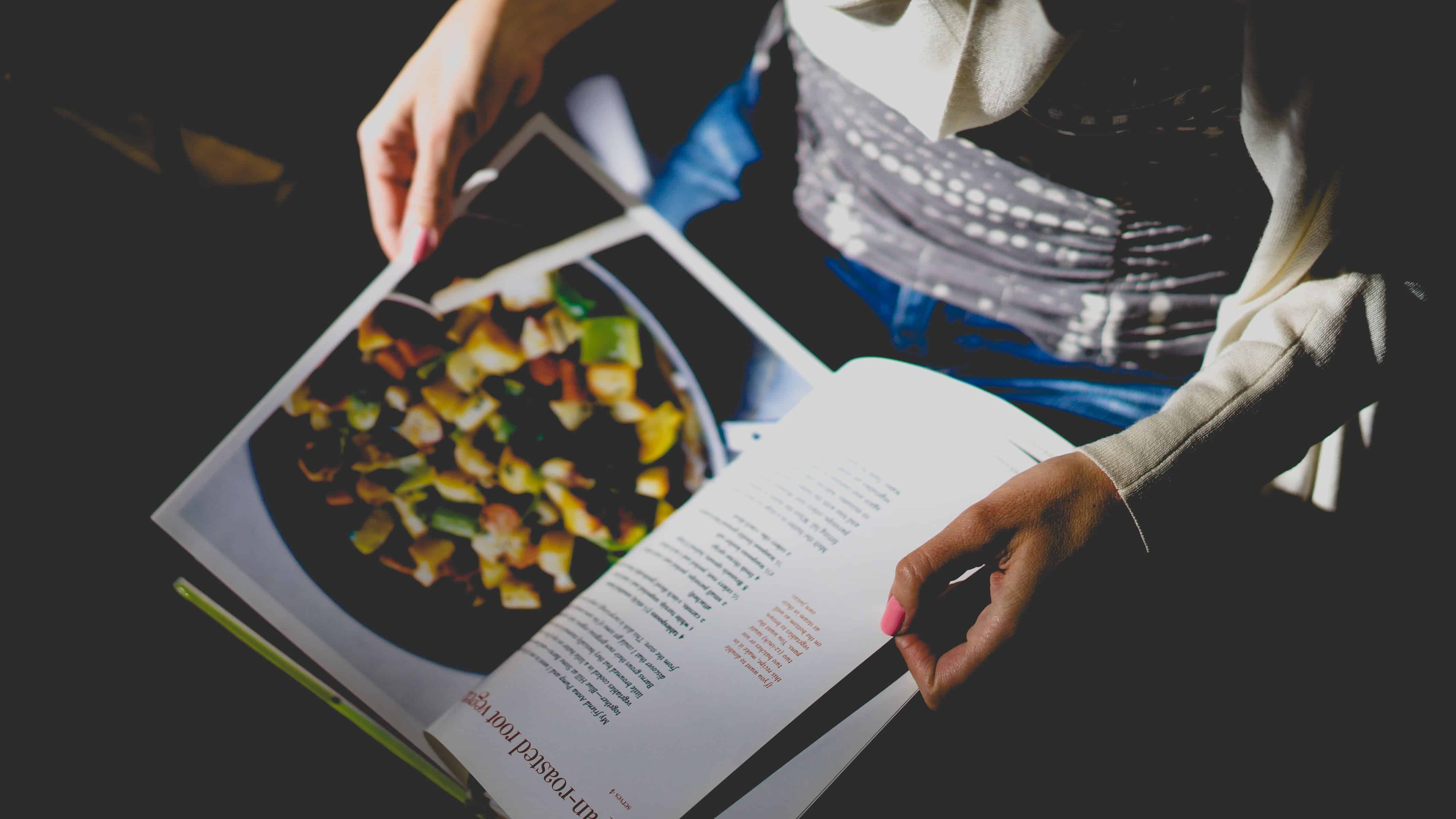 una persona sta leggendo un libro di cucina