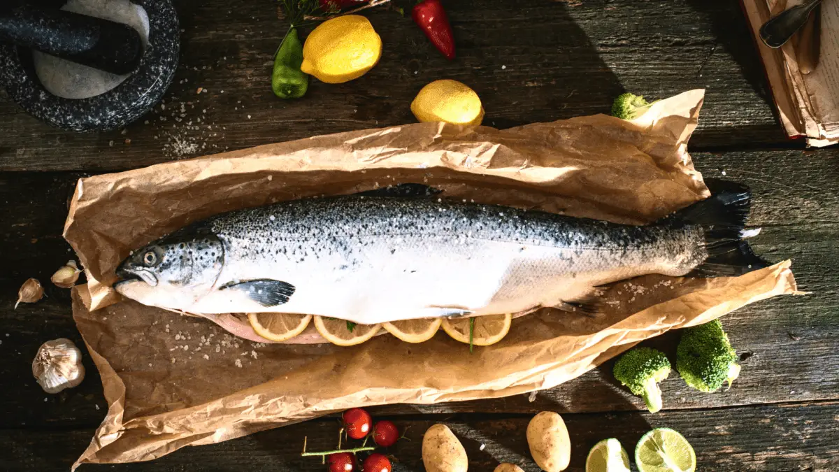 a whole salmon on butcher paper with slices of lemon inside